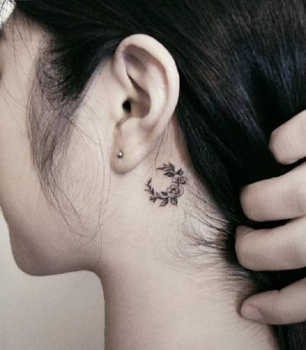 Tatuaje detrás de la oreja de una corona de flores