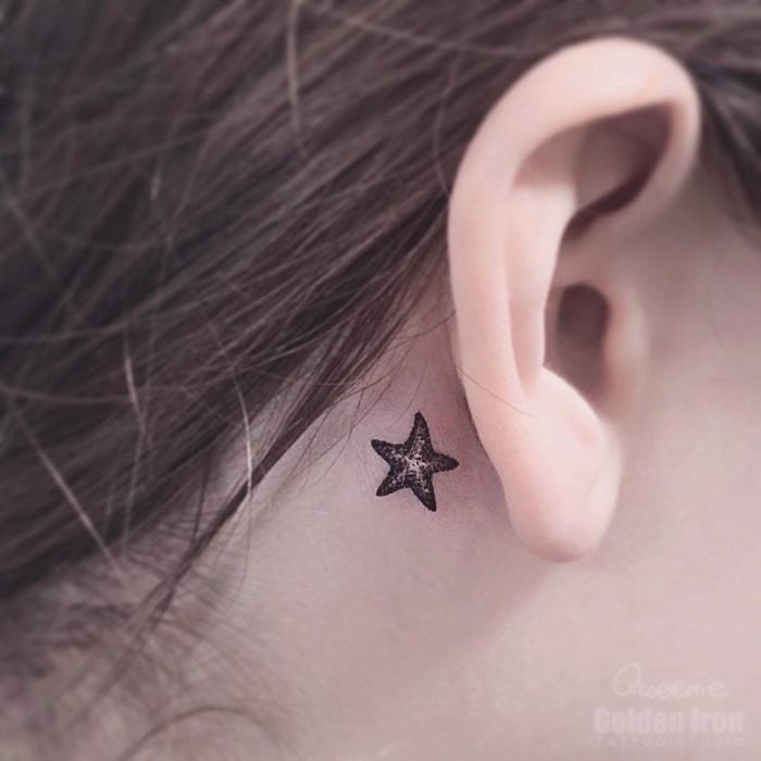 Tatuaje detrás de la oreja de una estrella de mar