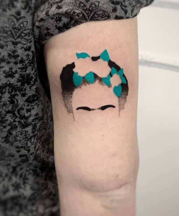 Tatuajes de Frida Kahlo de cejas y tocado en el brazo