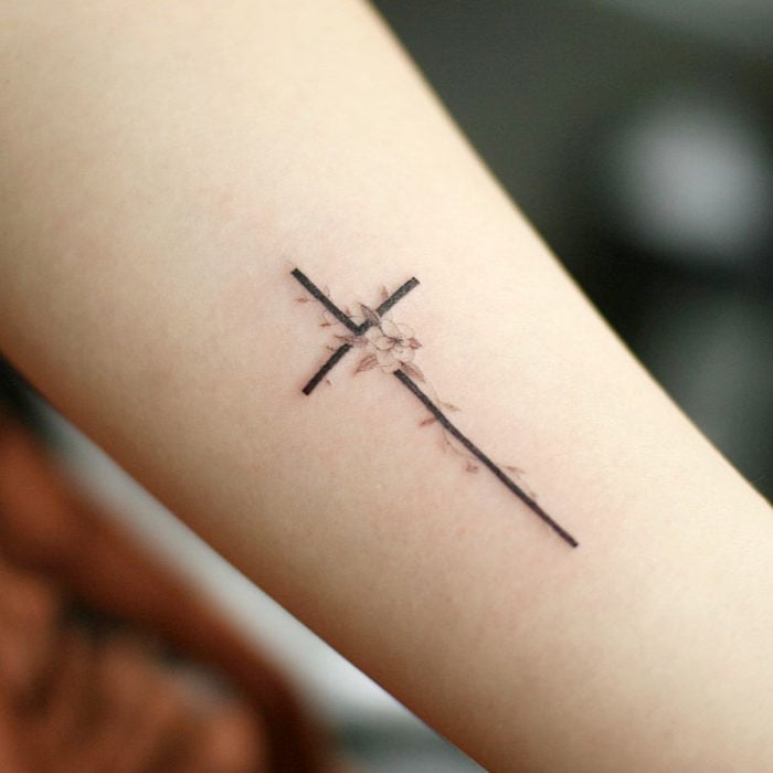 Tatuajes para regalarle a mamá el 10 de mayo; cruz con flores minimalista 