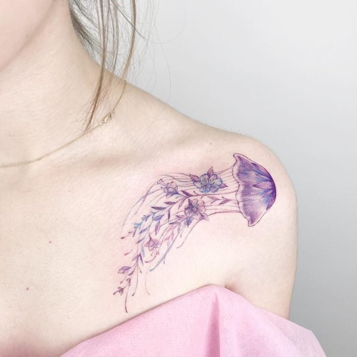 Chica con un tatuaje en forma de medusa de color morado 
