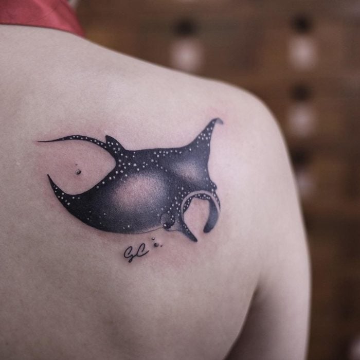 Chica con un tatuaje en forma de de pez