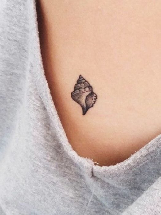 Chica con un tatuaje en forma de conchita de mar 