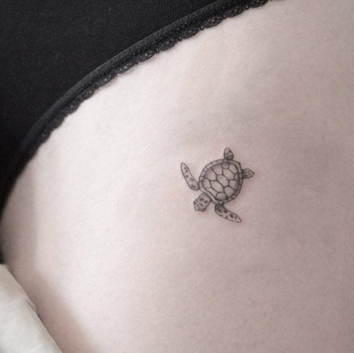 Chica con un tatuaje en forma de tortuga miniatura