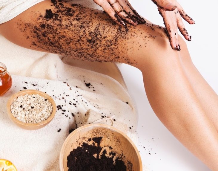 Chica aplicando mascarilla de café y avena en las piernas para eliminar celulitis