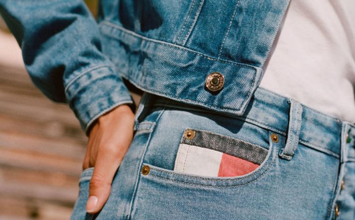 Mujer usando jeans y cazadora Tommy hecha con materiales 100 por ciento reciclados