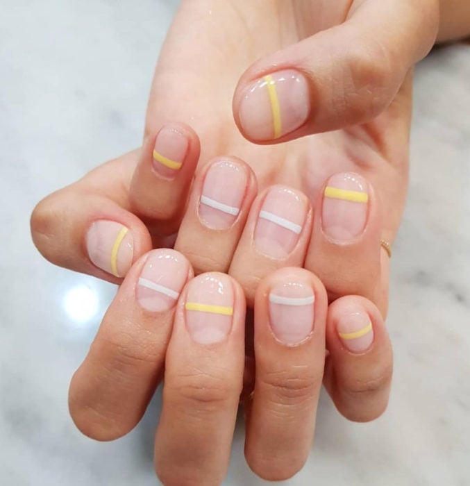 Diseños de uñas sencillos para hacer en casa; líneas horizontales con esmalte blanco y amarillo