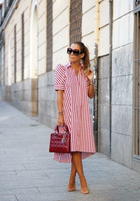 Chica usando un vestido holgado de color rojo con líneas blancas 