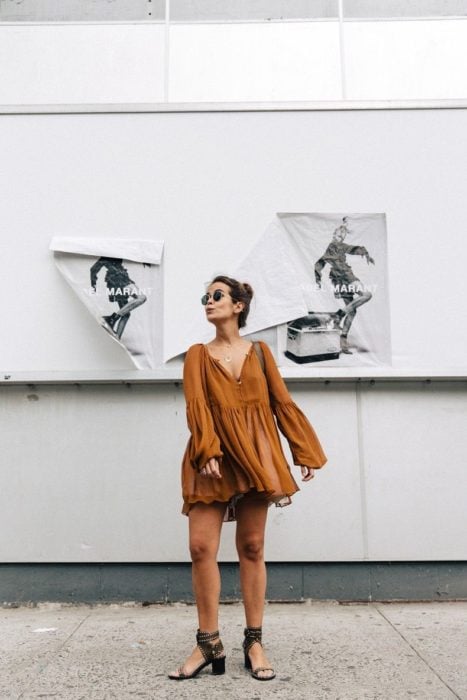 Chica usando un vestido holgado de color café de mangas anchas 