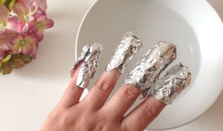 Dedos de las manos con papel aluminio