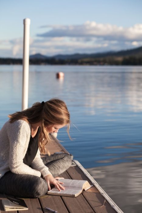 Chica leyendo en el muelle