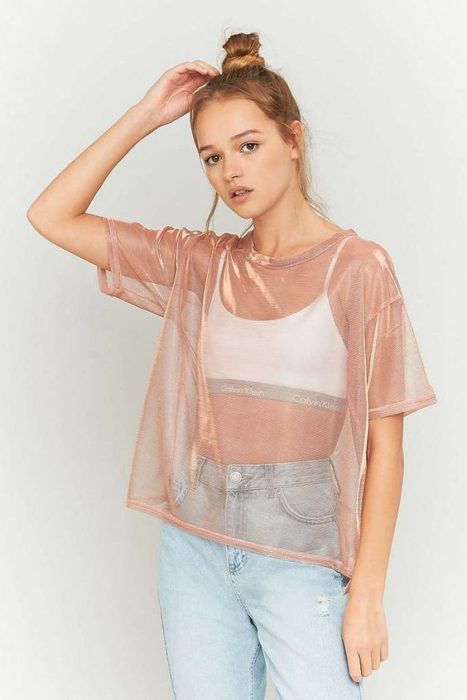 Chica usando top blnaco y blusa de transparencias en tono rosado