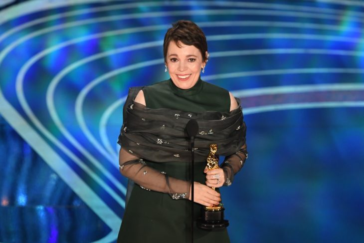 Olivia Colman sosteniendo una estatuilla a los premios óscar llevando un vestido verde seco