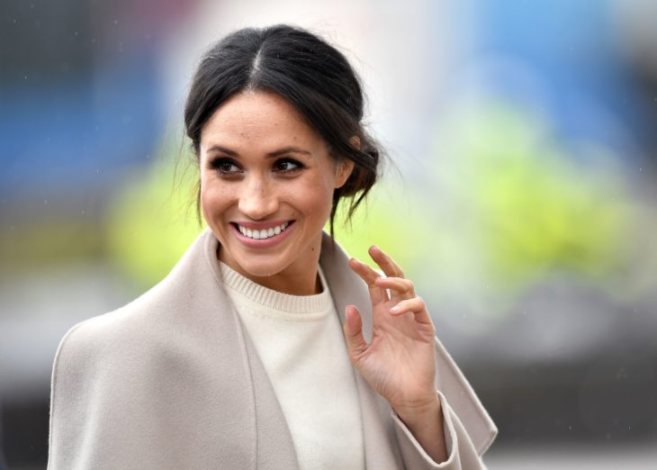 Meghan Markle llevando saco color beige y saludando