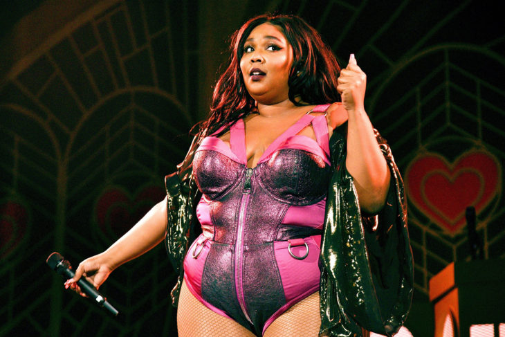 Lizzo en concierto llevando un corset rosa 