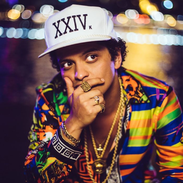 Bruno Mars llevando una gorra blanca haciendo una pose de preocupación