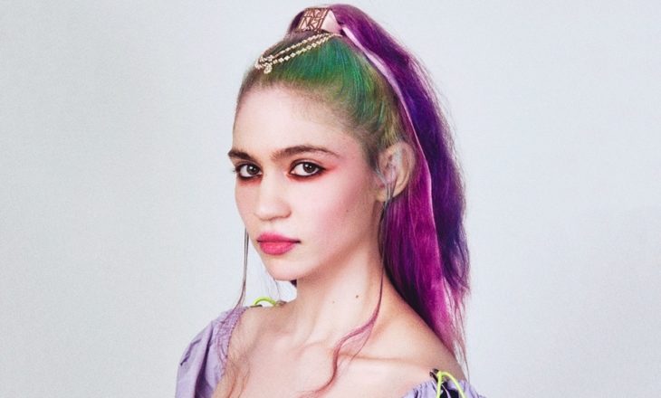 Grimes con cabello de colores rosa y verde posando para una sesión de fotos