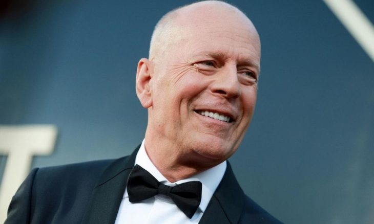 Bruce Willis con traje sastre negro y corbatín 