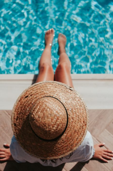 Chica con los pies dentro de la piscina