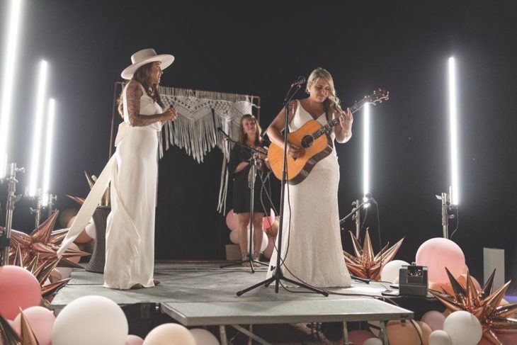 Brie y Lindsey en el escenario del autocinema cantando y tocando