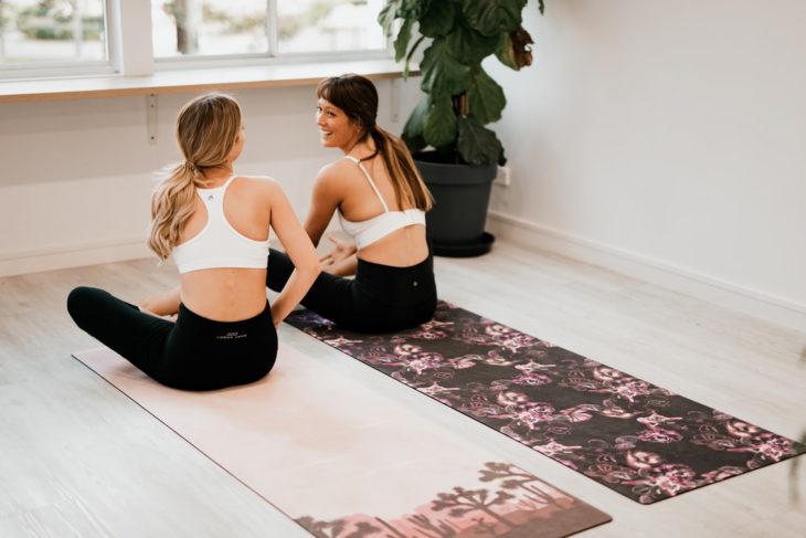 Amigas practicando ejercicio en mat de yoga