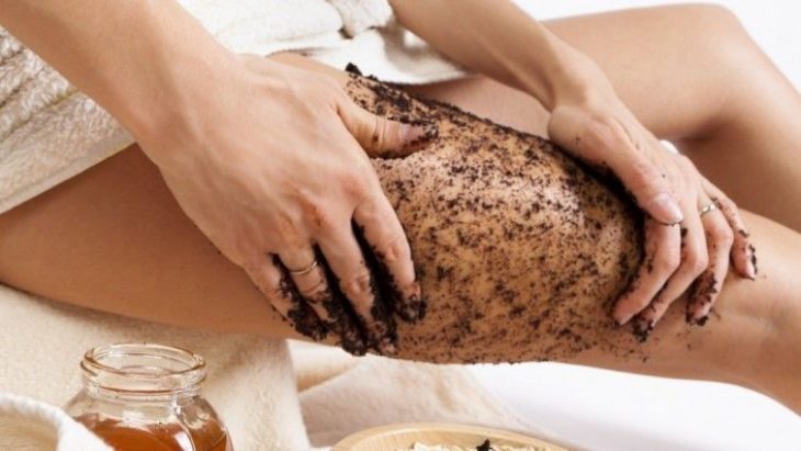 Chica exfoliando su cuerpo con café