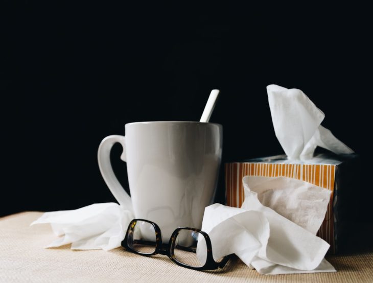 taza de té, pañuelos y lentes