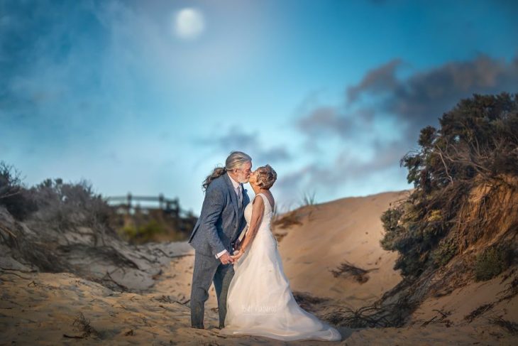 Fotografía por Abigail's Collection & The Groom's Room, pareja de abuelos besándose en la playa 