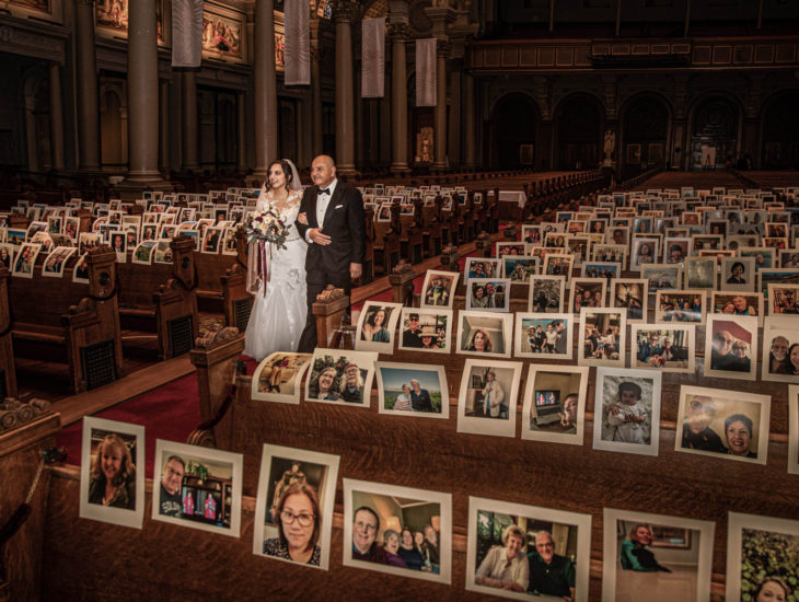 Parejas se casan en medio de cuarentena por coronavirus; esposos caminando en pasillo de iglesia con fotos de sus invitados en las bancas