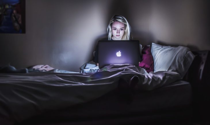 Chica trabajando en su laptop por la noche