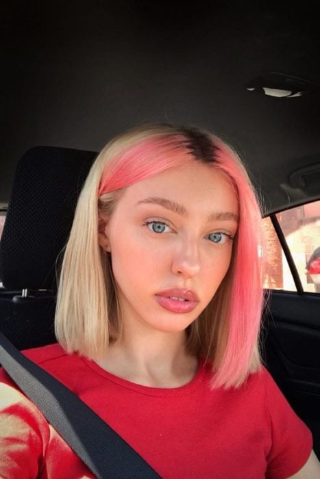 Chica rubia con melena corta lleva mechones de cabello rosas