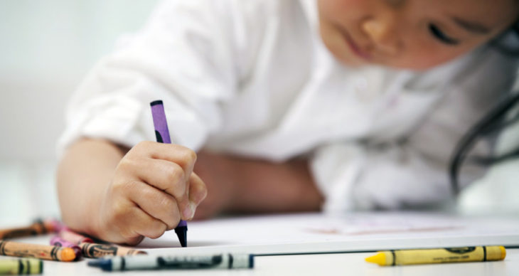 Niña dibujando con crayones