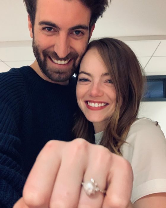 Emma Stone y Dave McCary mostrando su anillo de compromiso, abrazados y sonriendo