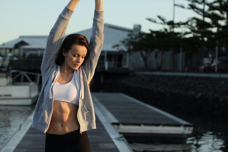 Chica estirándose en ropa deportiva