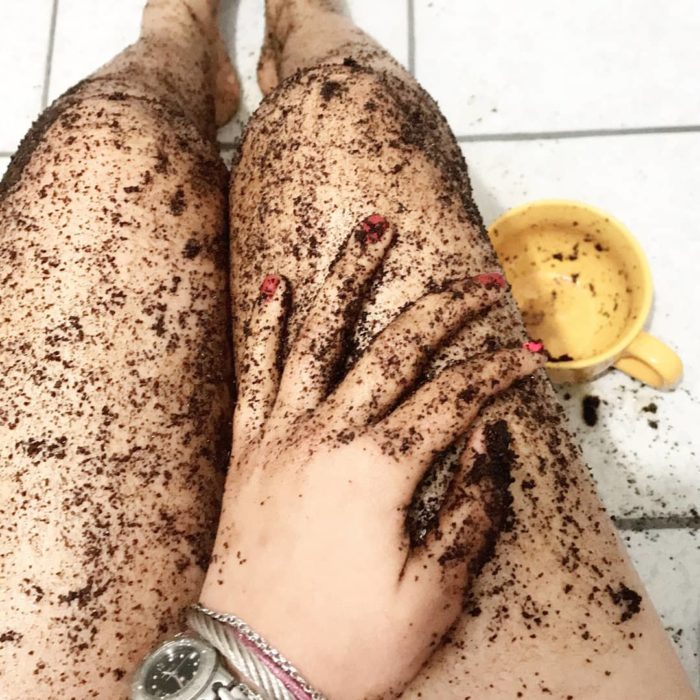 Chica exfoliando sus piernas con café