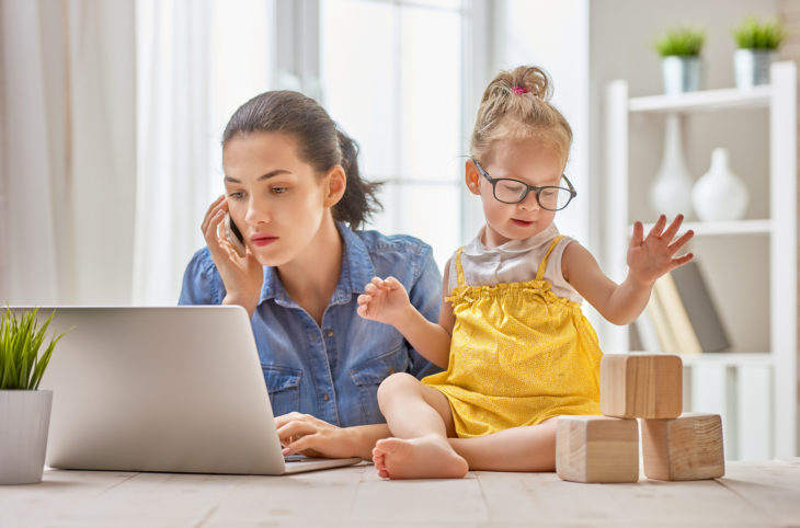 Mamá realizando trabajo en casa junto con sus hijos 