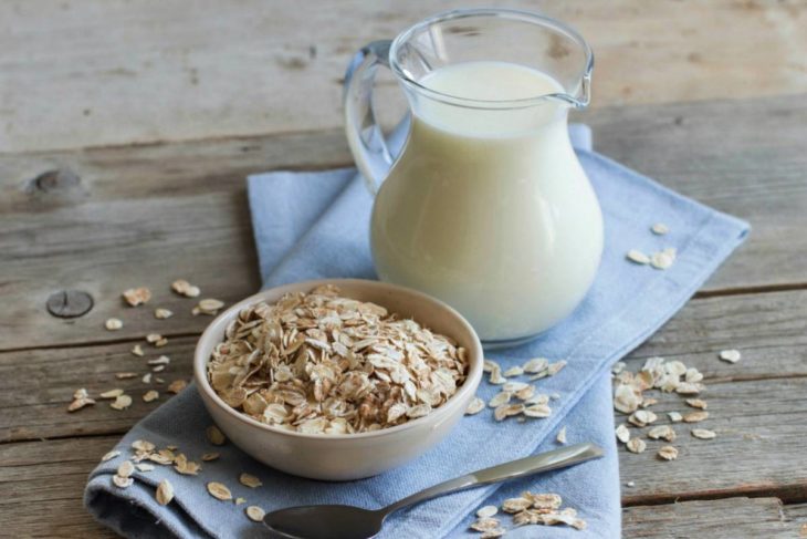 Tazón con avena y una jarra de leche fresca 