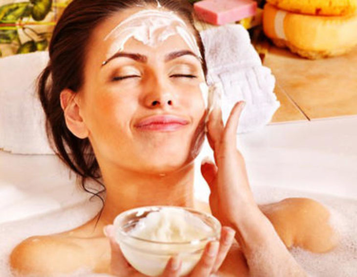 Chica poniendo mascarilla de avena con yogur sobre el rostro