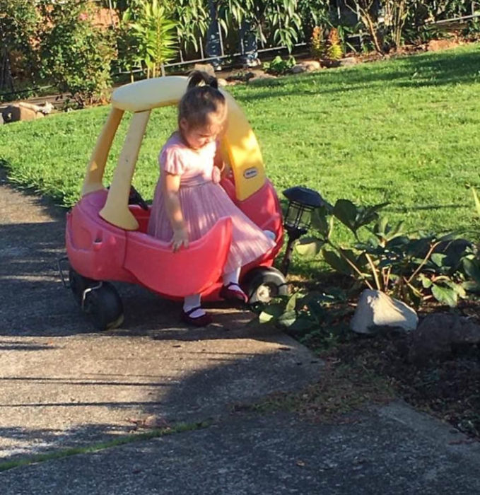 Niña huyendo del jardín al golpear una lampara con su auto de juguete 