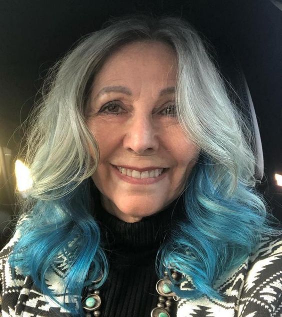 Mujer mayor con cabello largo y canosos y puntas azules
