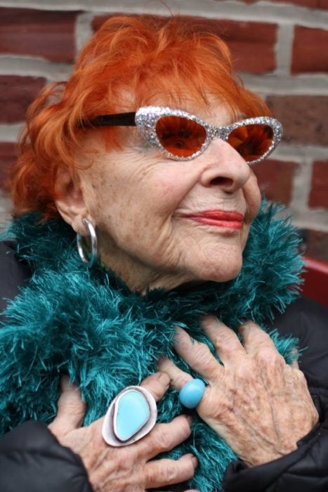 Anciana con bufanda turquesa y cabello corto color naranja vibrante