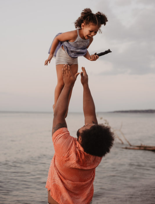 Frases del día del padre; papá jugando a lanzar a su hija en el aire