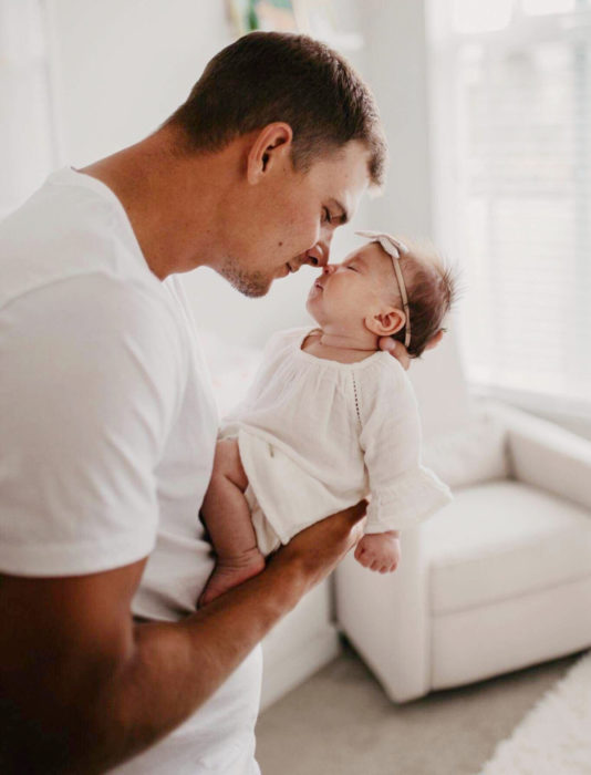 Frases del día del padre; papá cargando a su bebé recién nacida