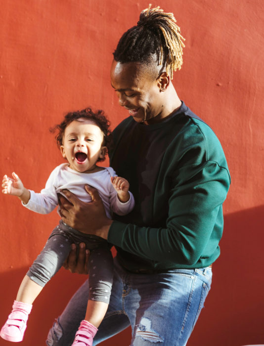 Frases del día del padre; papá abrazando y cargando a su hija bebé