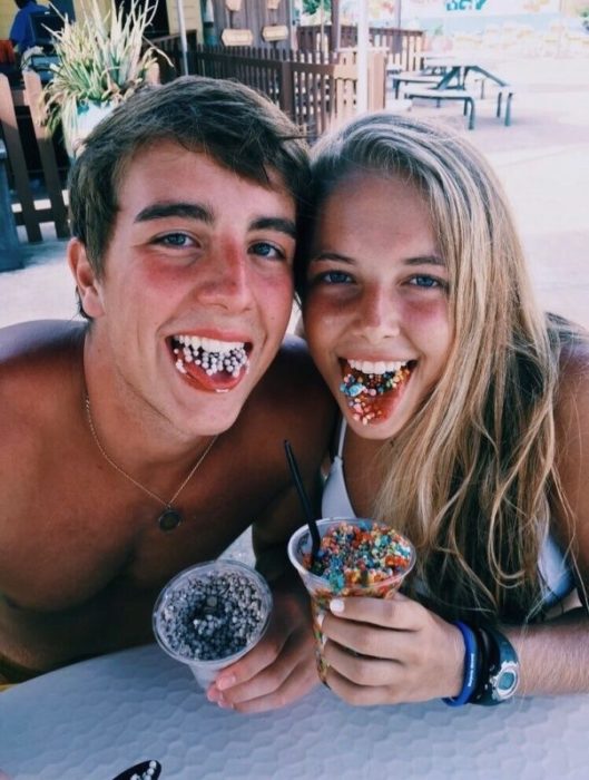 Pareja comiendo nieve con chochitos de colores