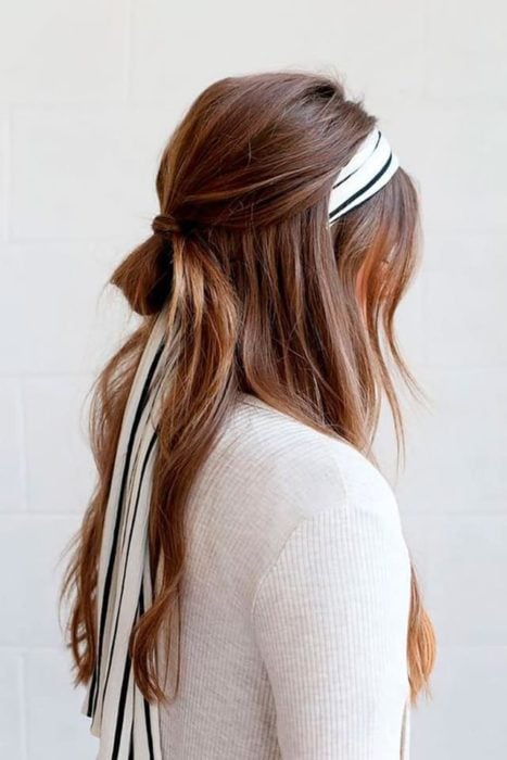 Chica castaña de cabello largo con una diadema en la cabeza
