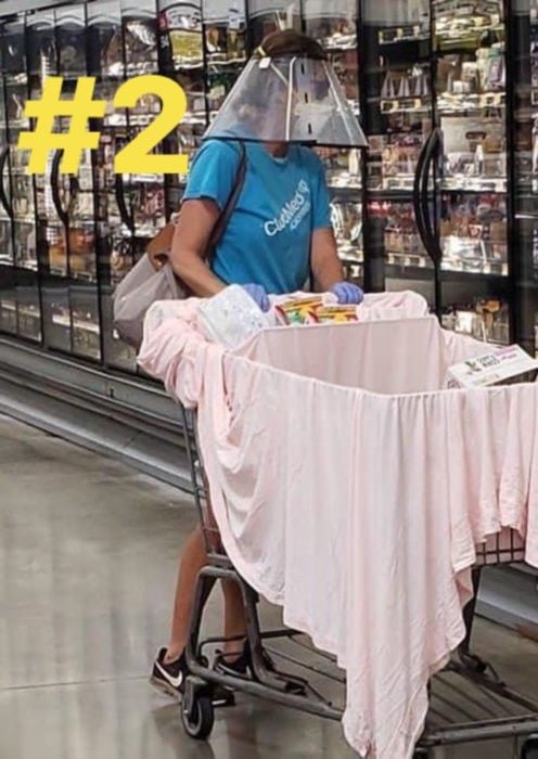 Señora en el supermercado usando una careta y una sabana para proteger la comida 