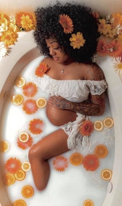 Mujer embarazada en la tina con flores