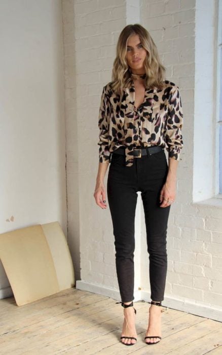 Chica rubia con blusa de leopardo, pantalón negro y sandalias de tacón negras