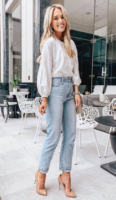 Chica rubia con jeans, blusa blanca y tacones nude